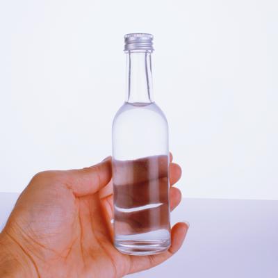 China Beverage 50ML 100ML Whiskey Glass Bottles Round Mini Clear Vodka Glass Bottle With Wine Bottle for sale