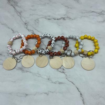 China Fashiontable Monogram Wooden Beads Various Sporty Bracelet Key Chain With Wooden Disc for sale