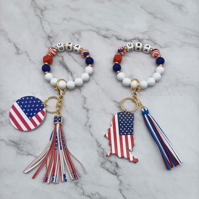 China Fashiontable USA Flag Wooden Disc Silicone Beaded Patriotic Tassel Bracelet Key Chain for sale