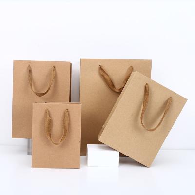 China Handled In Stock Wholesale Thickened Custom Advertising Gift Apparel Packaging Kraft Paper Shopping Bag With Handbag for sale