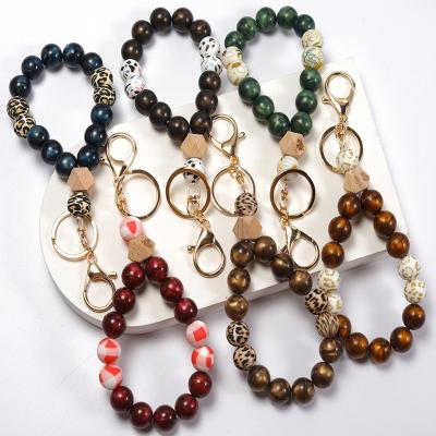 China Faux Fur Ball Pompom Chains Ring For Coin Bag Charn High Quality Printing Wood Pendant Silicone Key Bead Bangle Acrylic Monogram Bracelet Key Chain for sale