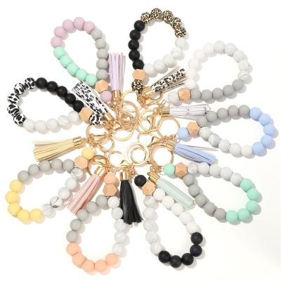 China Faux Fur Ball Pompom Chains Free Sample Leopard Silicone Beaded Bracelet Key Chain Bead Bracelet Car Bag Wood Pendant With PU Tassel for sale