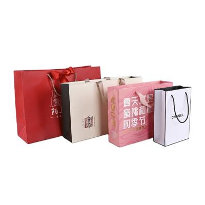 China Recyclable luxury paper gift shopping bag that bears customized logo. Portable shopping bag with handle for sale