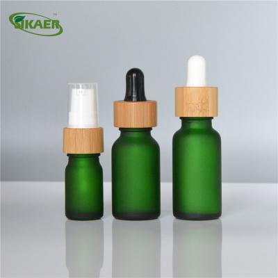 China Personal care frosted 5ml 10ml 15ml 20ml 30ml 50ml 100ml essential oil dropper green amber clear glass bottle with bamboo lid for sale