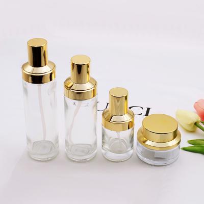 China Eco-friendly Wholesale Cheap Custom Round Shape Pump Glass Bottles 40ml 120ml Clear Cosmetic Bottle Jar Set With Luxury Glod Cap for sale