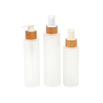 China Cheap Eco-friendly Flat Shoulder Spray Bottle Set Transparent Bamboo Pump Press Lotion Frosted Glass Bottle 200ml For Cosmetic for sale