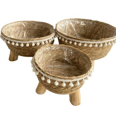 China Natural Plant Fiber Fringe Lace Plant Pot 100% Straw Basket Woven With Wooden Legs for sale