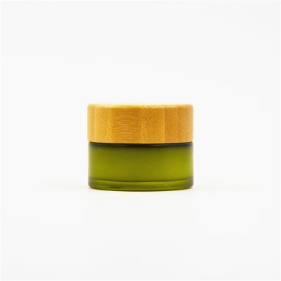 China Factory Cosmetic Green Frosted Face Cream Cosmetic Glass Jars With Bamboo Lid for sale