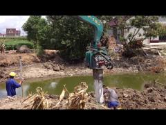 Cement sheet pile driving with mini excavator