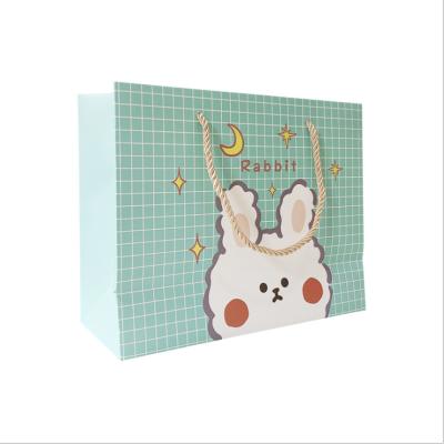 China Custom Recycled Materials Bag With Logo White Cardboard Cute Cartoon Rabbit Paper Bag With Ribbon Handle For Gift Shopping Bag Children's Day for sale