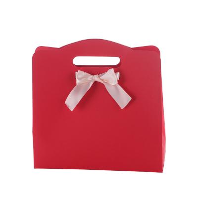 China Recycled Materials Hot-selling printed exquisite logo gift packaging bag with bowknot wedding gift handheld bag for sale