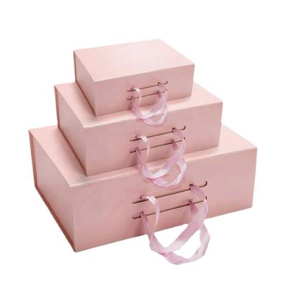 China Recyclable Wholesale Magnet Paper Cardboard Foldable Gift Boxes With Tough Strong Handle Tape For Packing Clothes And Shoes for sale