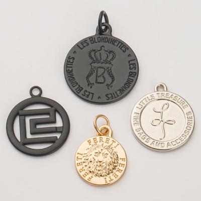 中国 Custom Gold Pendant Circle Metal Logo Tag Plated Disc Charms Tag for Purse Eco-Friendly 販売のため