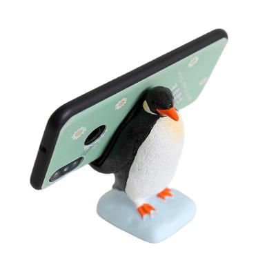 China Adjustable Resin Animal Cute Penguin Ornaments Mobile Stand Gift Cartoon Cell Phone Opening Desk Stand for sale