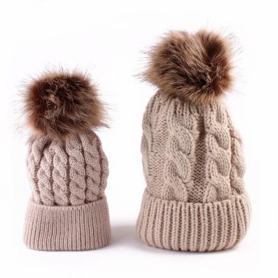 China COMMON Wholesale Winter Knit Beanie Soft Faux Fur Pom Pom Cable Hat Chunky Knit Slapped Beanie Hats for Women and Baby for sale