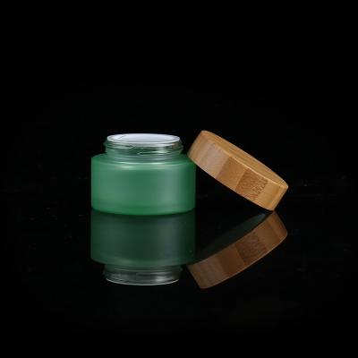 China Cosmetic Green Glass Bamboo Jar 30g 50g 100g Face Cream Jar Lid Glass Body Cream Jar for sale