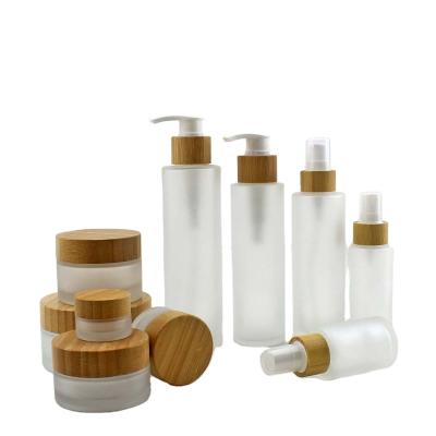 China 30ml cosmetic 50ml 100ml 150ml frosted glass clear cream lotion jar container with wooden and plastic cap custom logo for sale