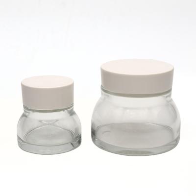 China Custom size 30g slim clear skincare personal care color glass jar with white and metal lids for sale