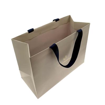 China Recyclable Custom Cream Color Printed Textured Paper Gift Bag With Embossed Gold Foil Logo for sale