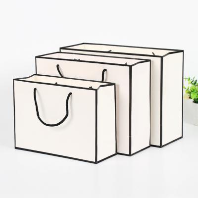 China MOQ100 Recyclable White Recycled Black Kraft Paper Bag Border Clothing Bag With Logo Custom Shopping Paper Bag for sale