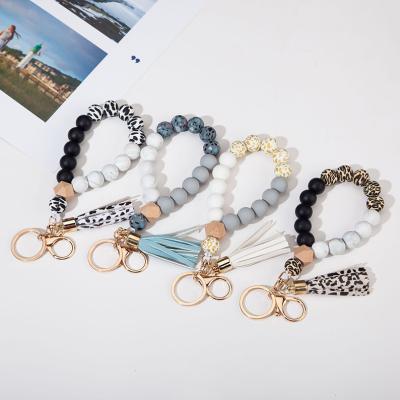 China Key Chain Holder Silicone Tassel Key Chain Wood Beads Women Wholesale Hot Selling Bracelet Key Ring for sale