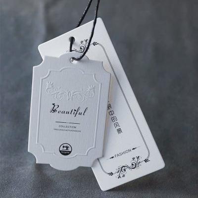 China Luxury Retail Recyled Clothing Shoes Hand Embossed Paper Hang Tag for sale