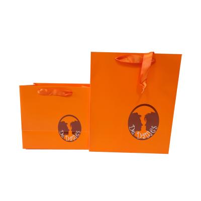 China Recyclable Customized Orange Paper Gift Bag With Ribbon Handle for sale