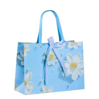 China Fresh White Chrysanthemum Pattern Sky Blue Cardboard Gift Bags With Ribbon Fashion Tote Bag for sale