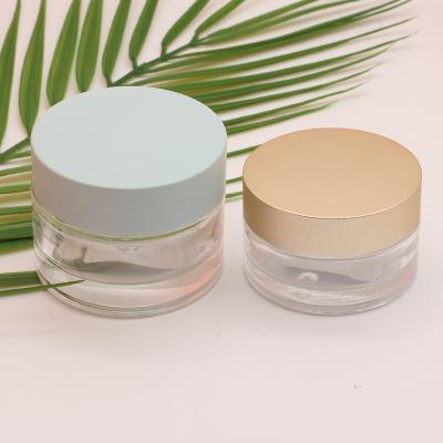 China Eco-friendly Round 30g 50g Custom Empty Clear Flat Cosmetic Container Black Luxury Glass Cream Jars With Gold Lid for sale