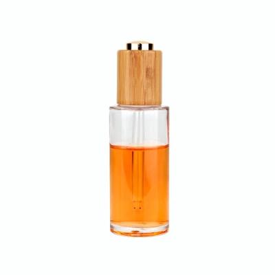 China Hot Selling Lead Free 50ml Round Clear Glass Essential Oil Dropper Bottle With Bamboo Dropper Cap for sale