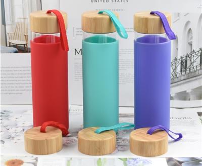 China Sustainable Plant Bamboo Lid Silicone Sleeve Soda Lime Glass Water Drink Bottle for sale