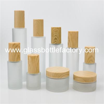 China New Frost Cylinder Glass Lotion Bottles With Wood Cap & Glass Cosmetic Jars With Wood Cap for sale