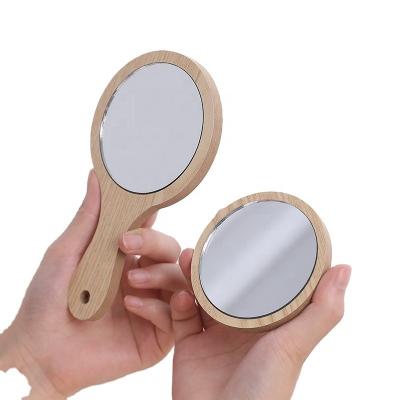 China Hand-held wooden beauty mirror portable handle dressing mirror home bathroom round small mirror for sale