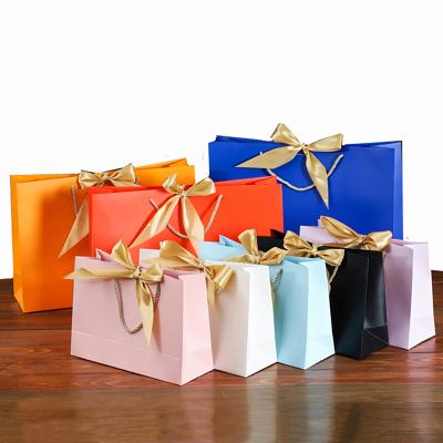 China Eco-friendly Gift Paper Bag With Present Ribbon Design Gift Paper Bag New Year Birthday Party Store Candy Cake Packaging Bag for sale