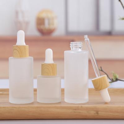 China Cosmetic Wholesale Cylindrical Bamboo Cap Dropper Bottles 30ml 50ml Essential Oil Glass Dropper Bottle G274 for sale