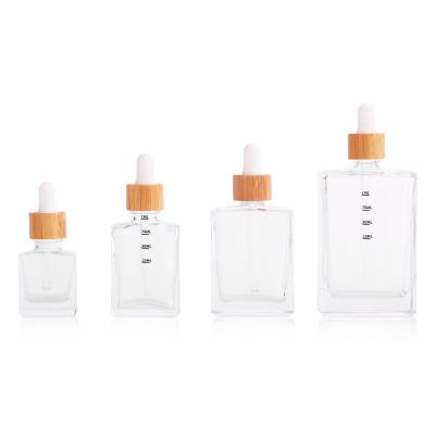 China 15ml 30ml 50ml 100ml Cosmetic Clear Square Rectangle Glass Bottle With Bamboo Lid for sale