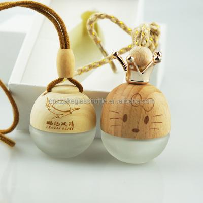 China Juice New Design 5ml Flat Round Car Hanging Glass Perfume Bottle With Wooden Cap With Crown Accessories for sale