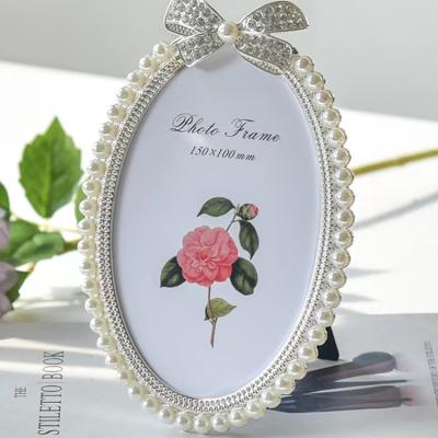 China Alloy Photo frame custom oval white pearl alloy photo frame light luxury 6 inch 7 inch wedding photo wedding gift for sale