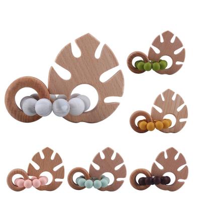 China Soft Chew Toy Chewbeads Baby Teether Modern Toy Food Grade Silicone Sensory Teething Ring With Wooden Leaf for sale