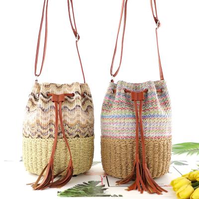 China Hot Sales Handmade Woven Women Straw Crossbody Bag Straw Bag Tassels Drawstring Bucket Shoulder Bag Eco-friendly for sale