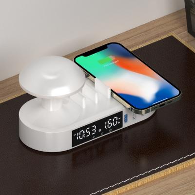 China Multi-functional new style mobile phone desktop clock touched night light alarm radio charging station phone holder fast charger for sale