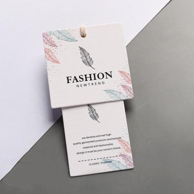 China Eco-friendly Custom Printed Black White Gold Colors Garment Swing Tags Cardboard Hang Tags For Clothing Clean Logo for sale