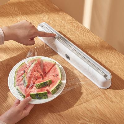 China Food Cling Wall Mounted Adjustable Plastic Wrap Tin Foil Storage Cutter Wrap Dispenser Suction Cup for sale