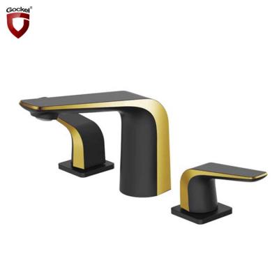 China Metered Faucets Kaiping Gockel Black And Gold Deck Mounted Double Handle 3 Hole Bathroom Basin Faucet for sale