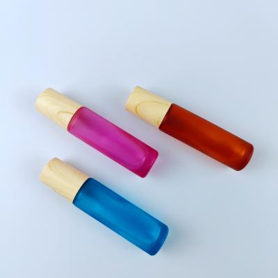 China 10ml Rainbow Color Cosmetic Essential Oil Roller Glass Bottles With Wooden Printing Lids for sale