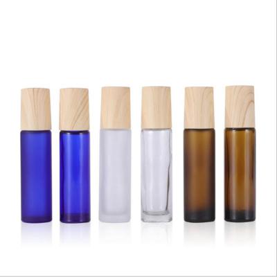 China 10ml Essential Oil Cosmetic Transparent Glass Roller Bottles With Transfer Printing Wooden Lids for sale