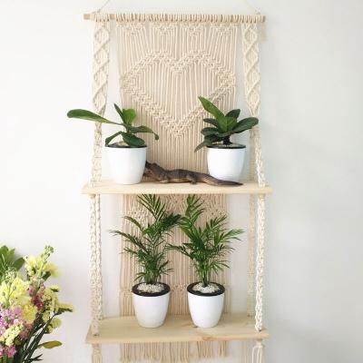 China 100% Handmade Woven Macrame Plant Hanger Rope Pot Hanging Racks With Double Shelf Wood Wall Hanging Decor for sale