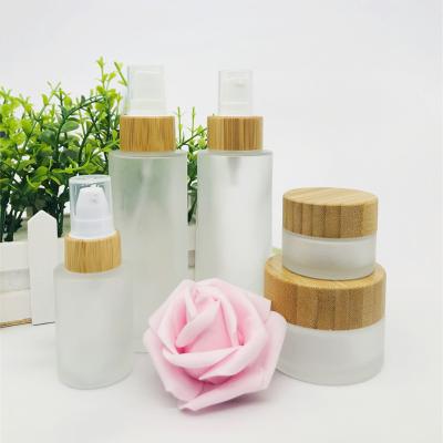 China Cosmetic Empty Sets Clear Frosted Glass Cream Jar With Bamboo Lid Glass Bottle For Cosmetic Toner Lotion Packaging for sale