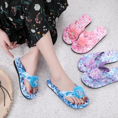 China Summer durable flip flops European and American flat sandals, sweet flowers, beach wear, foot massage bottom, slope heel slippers for sale