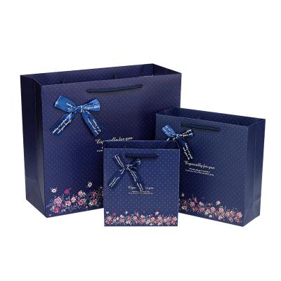 China Disposable Custom Print Bowknot Gift Bag Fashion Dark Blue Flower Large Shopping Packaging Paper Bag for sale